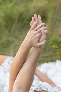 man and woman holding hands showing engagement ring in waterford