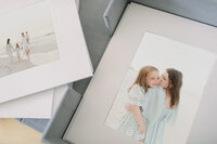 Custom matted prints featuring beach family portraits displayed in a linen keepsake box