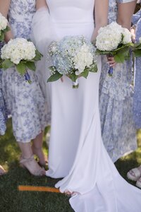 Close up detail of floral bridesmaid dresses and hydrangea bouquets.