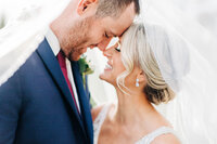 Close up photo of bride and groom with noses touching
