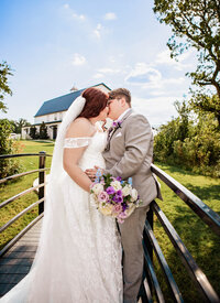Bride and Groom sharing an intimate moment on a bridge at The Barn At Paradise Place captured by Graceful Ray Photography in Fort Worth Texas