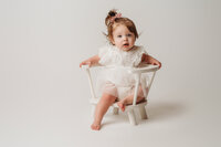 Charleston Cake Smash Photographer- Baby looks into the camera during Milestone Portraits at Holy City Babies Portrait Studio in Charleston, SC.