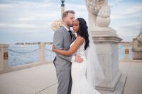 A joyful bride and groom stand together after their wedding at The Treasury on the Plaza in St. Augustine, surrounded by the historic venue's elegant architecture, capturing the timeless beauty of their special day. | Photo taken by St Augustine Wedding Photographer, Phavy Photography