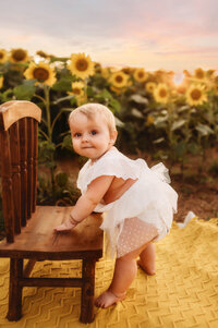 Charleston Baby Milestone Photographer - Baby grins at the camera during her Milestone Portrait Session at Holy City Babies Portrait Studio in Charleston, SC.
