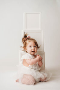 Charleston Cake Smash Photographer -- Baby celebrates her first birthday with a Cake Smash Photoshoot at Holy City Babies Portrait Studio in Charleston, SC.