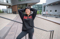 Model wearing Bear Cats half zip pullover in black with red writing