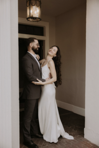Smiling bride and groom in doorway of Maison Charlottesville. Amy Mitchell Photography.