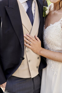 Up close photo of brides hand and ring on grooms chest