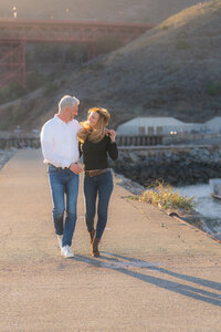 laughing couple sunset engagement photos by the bay and golden gate bridge at cavallo point