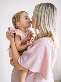 Mom kissing her toddler daughter