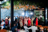 Guests fill the dance floor beneath hanging greenery and glowing ring lights as music plays late into the evening in Antigua Guatemala wedding.