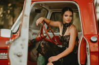 Senior portrait at Triple T Farms in Fruitdale, Alabama — sitting in a classic red truck.