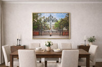 Framed child portrait displayed in a light neutral interior featuring a white lace dress and iron garden gate backdrop