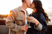 Newly engaged couple kisses and cheers during golden hour in downtown Knoxville