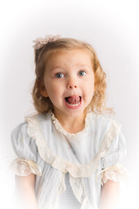 Little girl makes a silly face at the camera during her Heirloom Portrait Session in Charleston, SC.