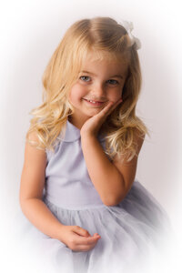 Little girl smiles into the camera during her Heirloom Portrait Photoshoot in Charleston, SC Portrait Studio.
