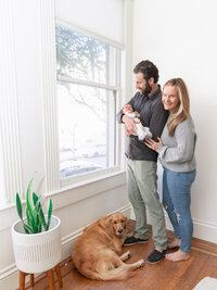 Los Angeles lifestyle newborn photography family photo at home with a newborn and their dog, captured in true to life color with soft natural light and candid documentary moments.