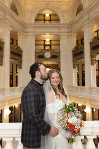 groom kissing brides head at Detroit Wedding Photography Whitney Hotel