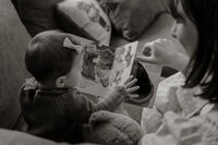 Mother reading with her baby in a New England home. Lifestyle family photography capturing tender parent-child moments in natural light.