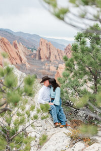 Roxborough State Park engagement session—couple on a rocky overlook framed by pine trees and red rocks