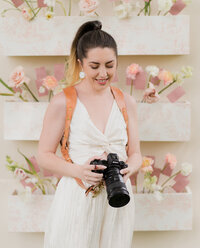 wedding stylist and creative director kaylyn leighton poses on floor for headshot next to wedding details