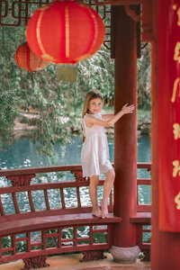 Child in white dress posed in garden pavilion in Eastern North Carolina