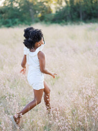 Little girl frolicking in the meadow in Discovery Park