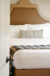 Bedding and headboard detail in a renovated Estancia La Jolla guest room