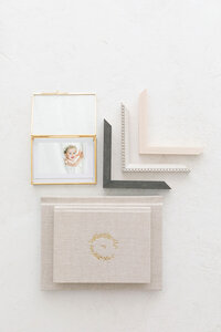 Flat lay of heirloom portrait products including albums, frames, and velvet keepsake boxes