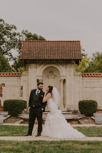 Newlyweds standing together in front of historic stone architectural details during a wedding portrait session at the Western Reserve Historical Society in Cleveland, Ohio.