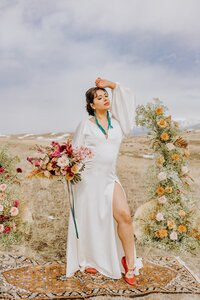 Bride holds a colorful bouquet in front of her wedding altar in paradise valley.