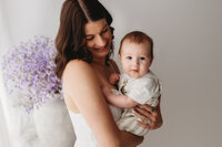 Charleston Mini Sessions - Mother embraces her baby during Mother's Day Mini Session at Holy City Babies in Charleston, SC.