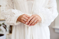 Bride holds hands together with engagement ring while getting ready for Tennessee wedding