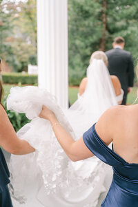 Bridesmaids holding brides lace veil