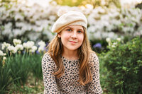 Child portrait of girl in leopard print dress surrounded by white spring blossoms