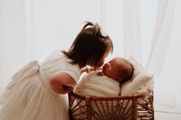 Toddler sitting beside newborn baby during sibling photoshoot