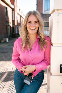 Vrolijk branding portret van vrouw met roze blouse op brug in Alkmaar