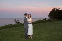 Bride and Groom pose on the lawn of the Wianno Club at sunset. Jessica Hennessey Weddings, wedding reception at Wianno Club. Deborah Zoe Photography.