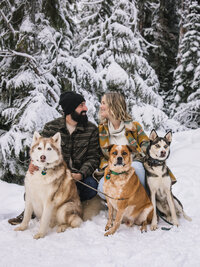 Couple and their dogs in the snow