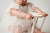 Charleston Cake Smash Photographer- Baby looks into the camera during Milestone Portraits at Holy City Babies Portrait Studio in Charleston, SC.