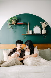 Two moms and newborn baby on bed natural light session South Florida