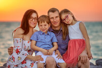 Family smiling together during a sunset beach photography session in New Bern, North Carolina