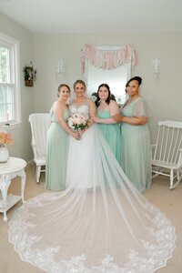 Bride and bridesmaids posing together inside The Love Loft in Monroe, Connecticut
