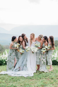 Bridesmaids stand beside the bride in long green gowns