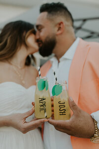 Bride and groom share a kiss and a lemonade together on their wedding day