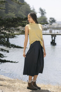 Chartreuse knit tank and navy midi skirt seen from behind at the water's edge