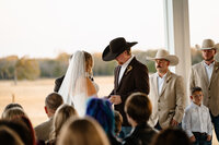 a bride and groom exchange vowels outdoors at chandelier farms in terrel, texas captured by shelyl voss