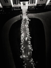 An artistic top-down view of a sparkler exit at a waterfront wedding, showcasing refined composition and intentional imagery.