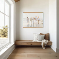 Oversized framed beach family portrait displayed as wall art in a light-filled home entryway