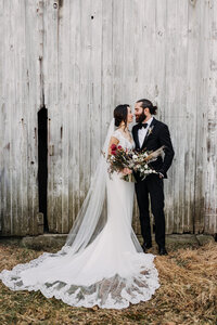 bride and groom with old barn